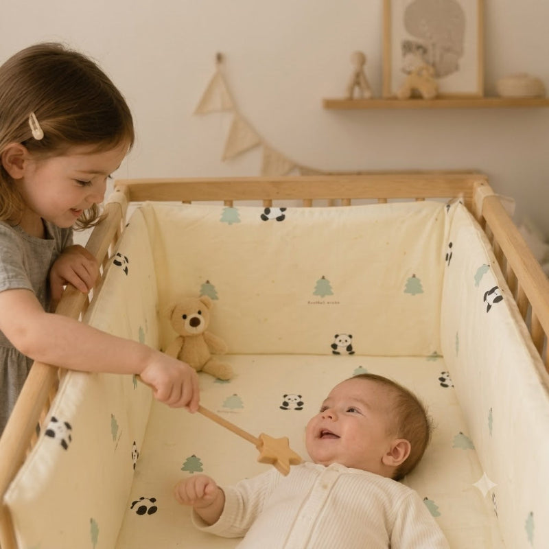 tour de lit ourson bébé s'amuse avec sa soeur dans berceau