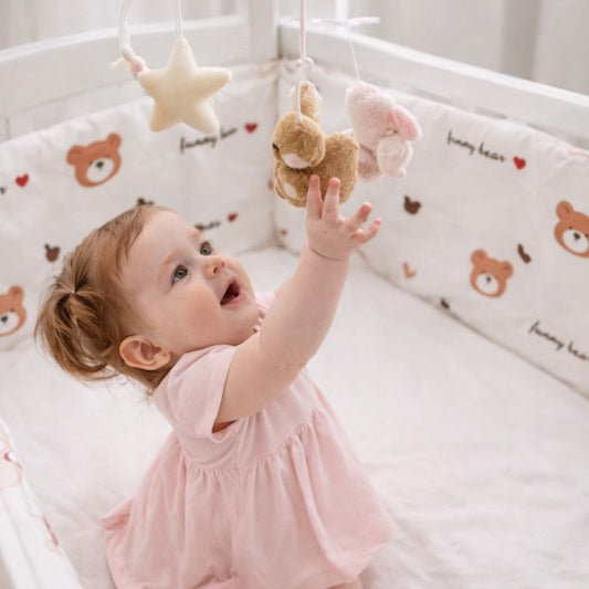 tour-de-lit-ourson-fille-attrape-mobile