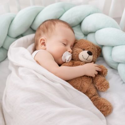 tresse-de-lit-verte-tendre-qui entoure bébé qui dort avec son ourson